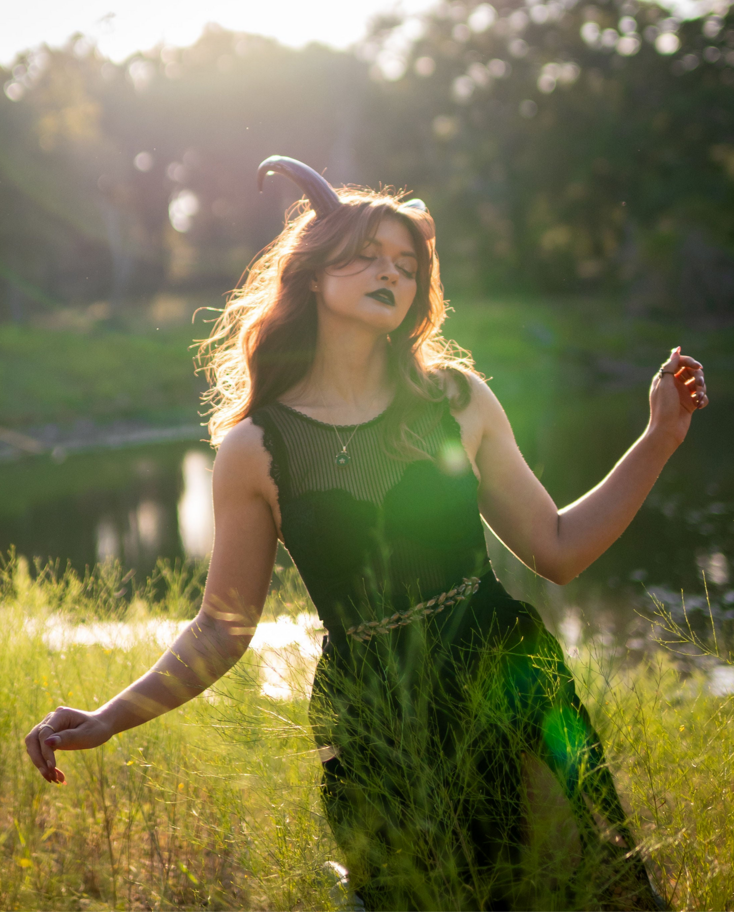 Bambi Bloodmoon models Azazel Horns by Haus of Brimstone in a Texas field at golden hour. Photo by Optic Onslaught.