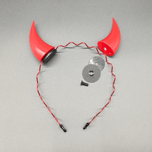 Two scarlet red incubus horns and a headband, with one horn detached showing the silicone grip disc, anchor disc, and screw.