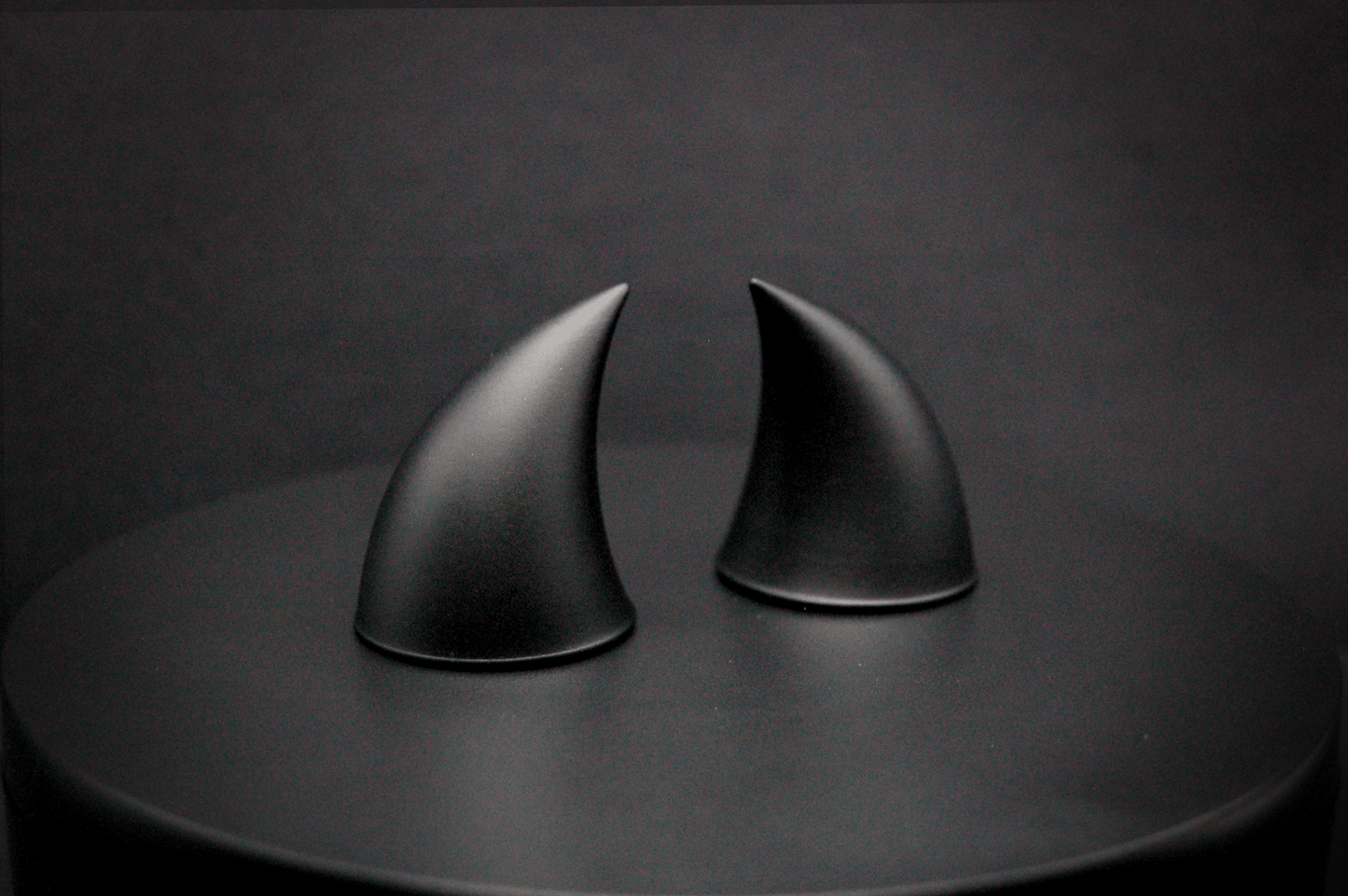 Side view of imp devil horns in black with a matte finish.