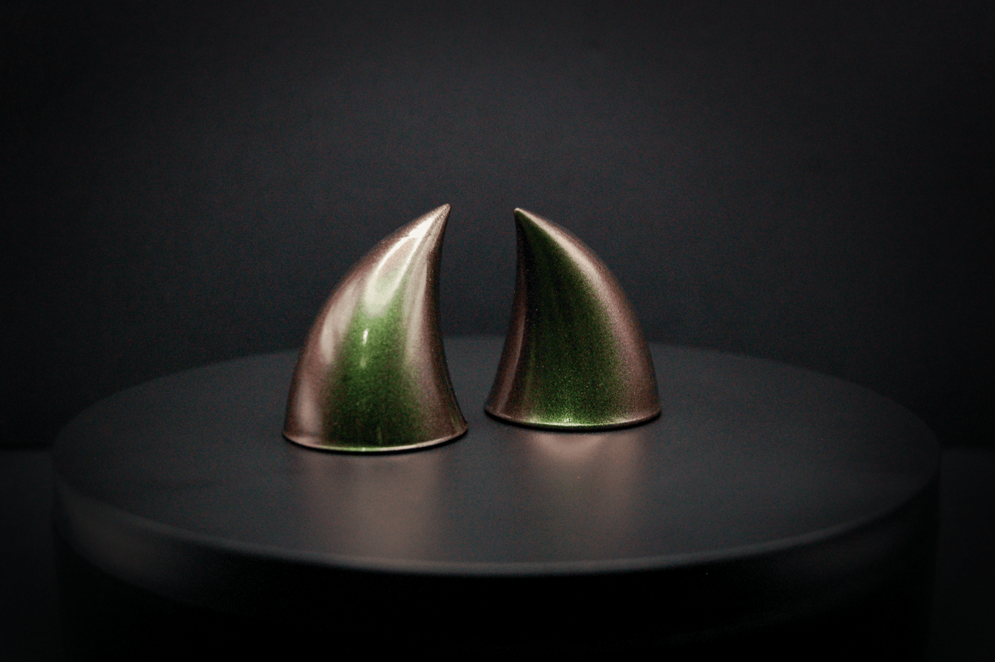 Side view of imp devil horns in metallic coppery green.