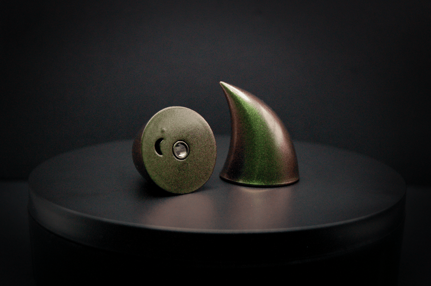 Bottom view of imp devil horns in metallic coppery green, showing a threaded insert on the base.