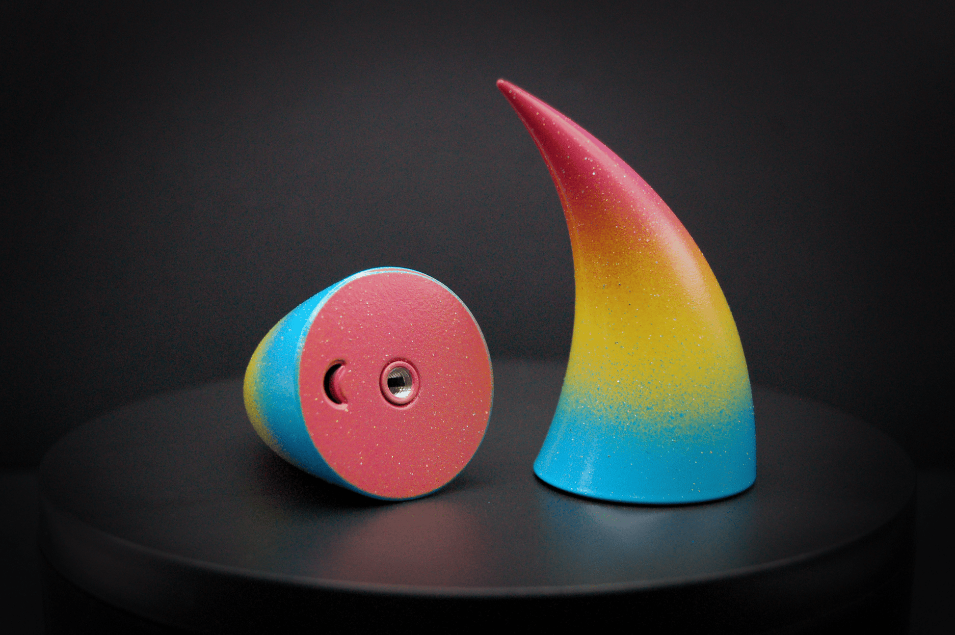 Bottom view of imp devil horns in a  sky blue, to bright yellow, to warm pink ombré, the colors of the pansexual pride flag  with a glittery finish, showing a threaded insert on the base.