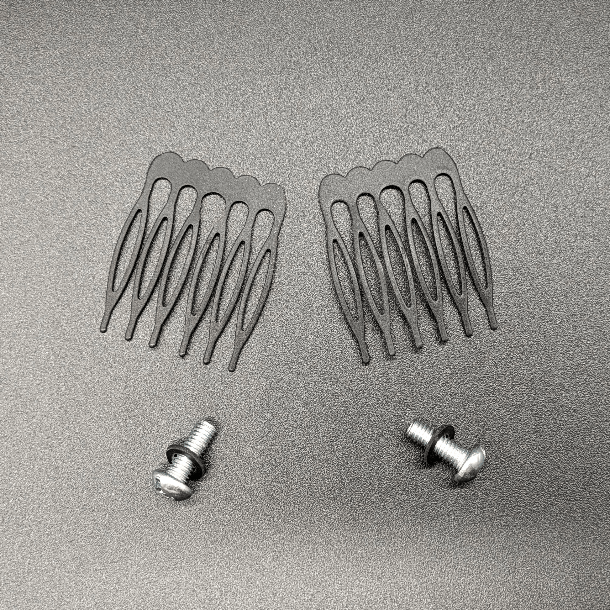 Two catacomb hair combs and two screws with silicone washers.