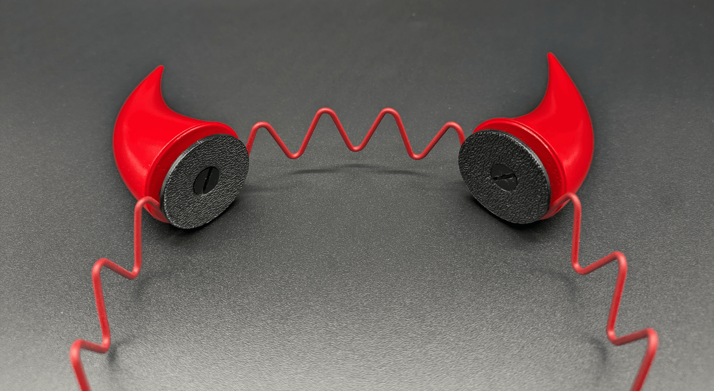 Closeup view of two scarlet red incubus horns attached to a headband.