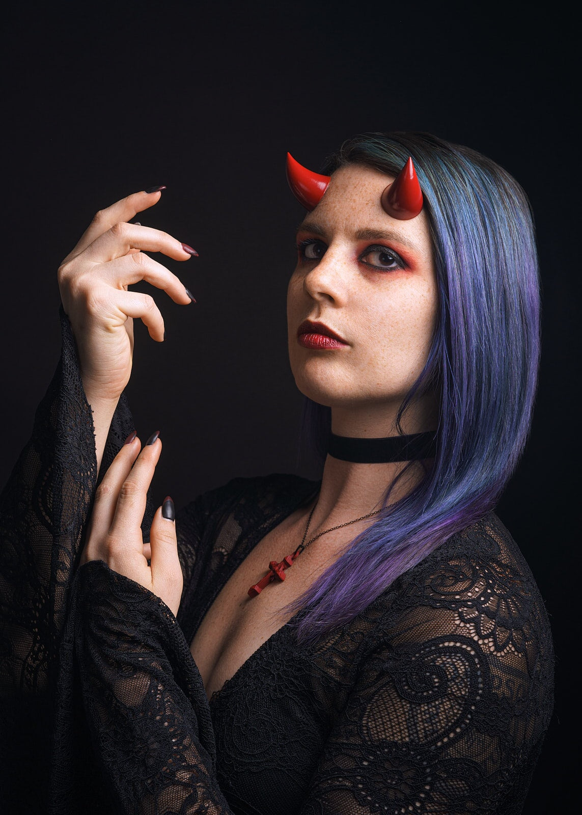 Model Splitty Kitty poses in gothic attire wearing bordeaux red imp horns on her forehead. Photo by Brian Keyes.