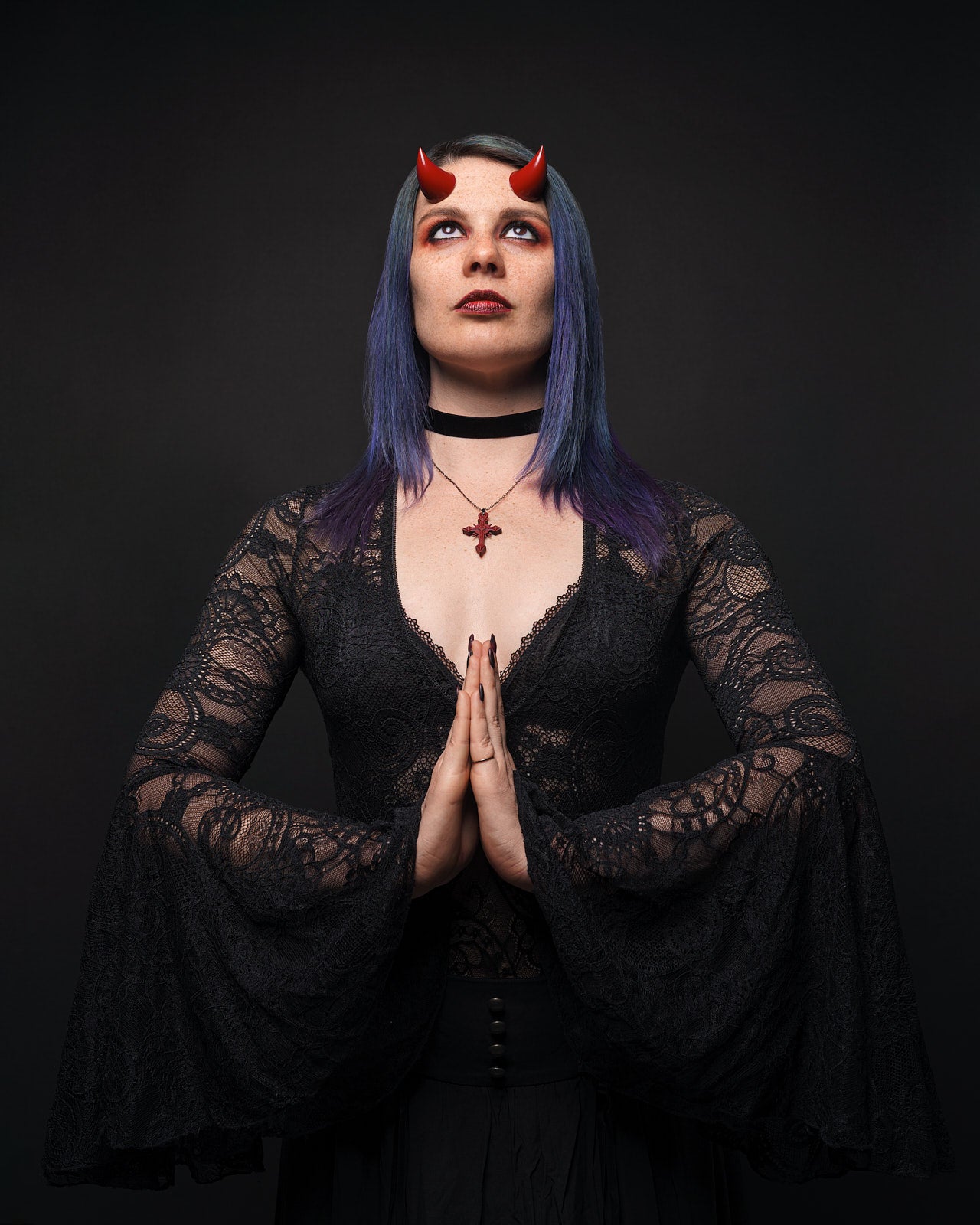 Model Splitty Kitty makes a prayer pose in red imp horns, looking skyward. Photo by Brian Keyes.