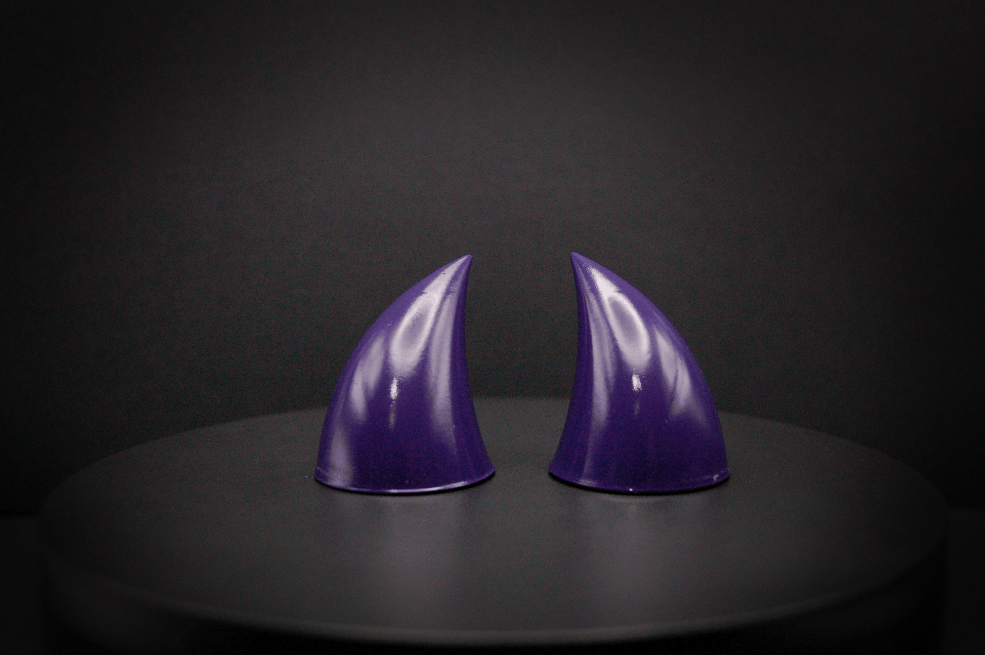 Front view of imp devil horns in belladonna violet, a dark purple with a glossy finish.
