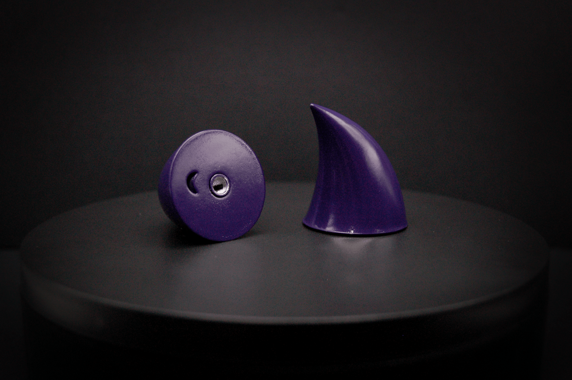 Bottom view of imp devil horns in belladonna violet, a dark purple with a glossy finish, showing a threaded insert on the base.