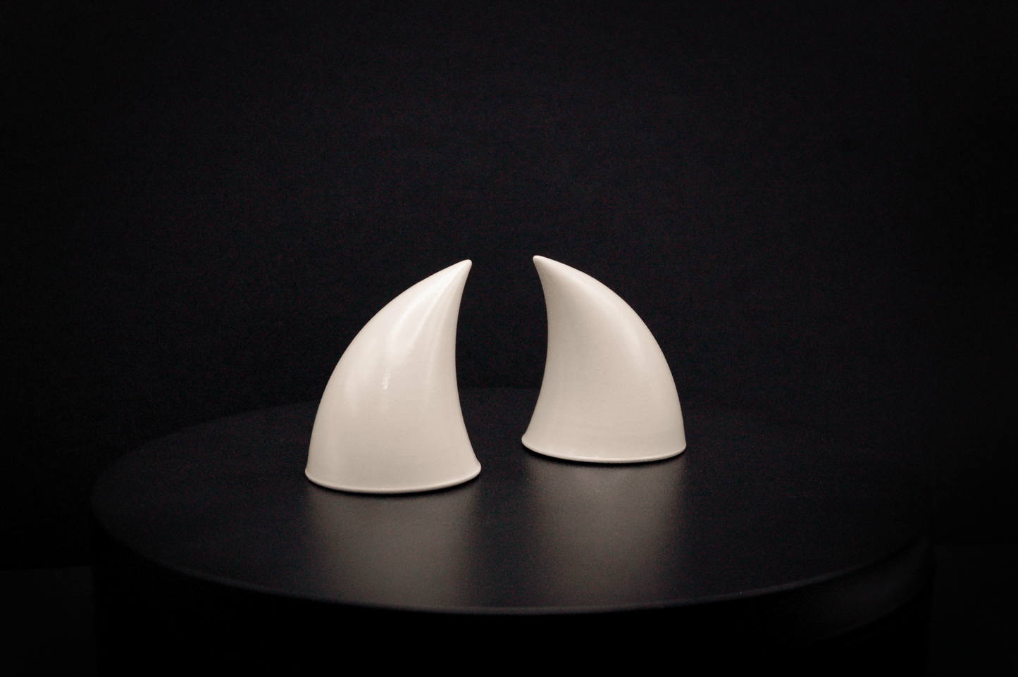 Side view of imp devil horns in bone white with a glossy finish.