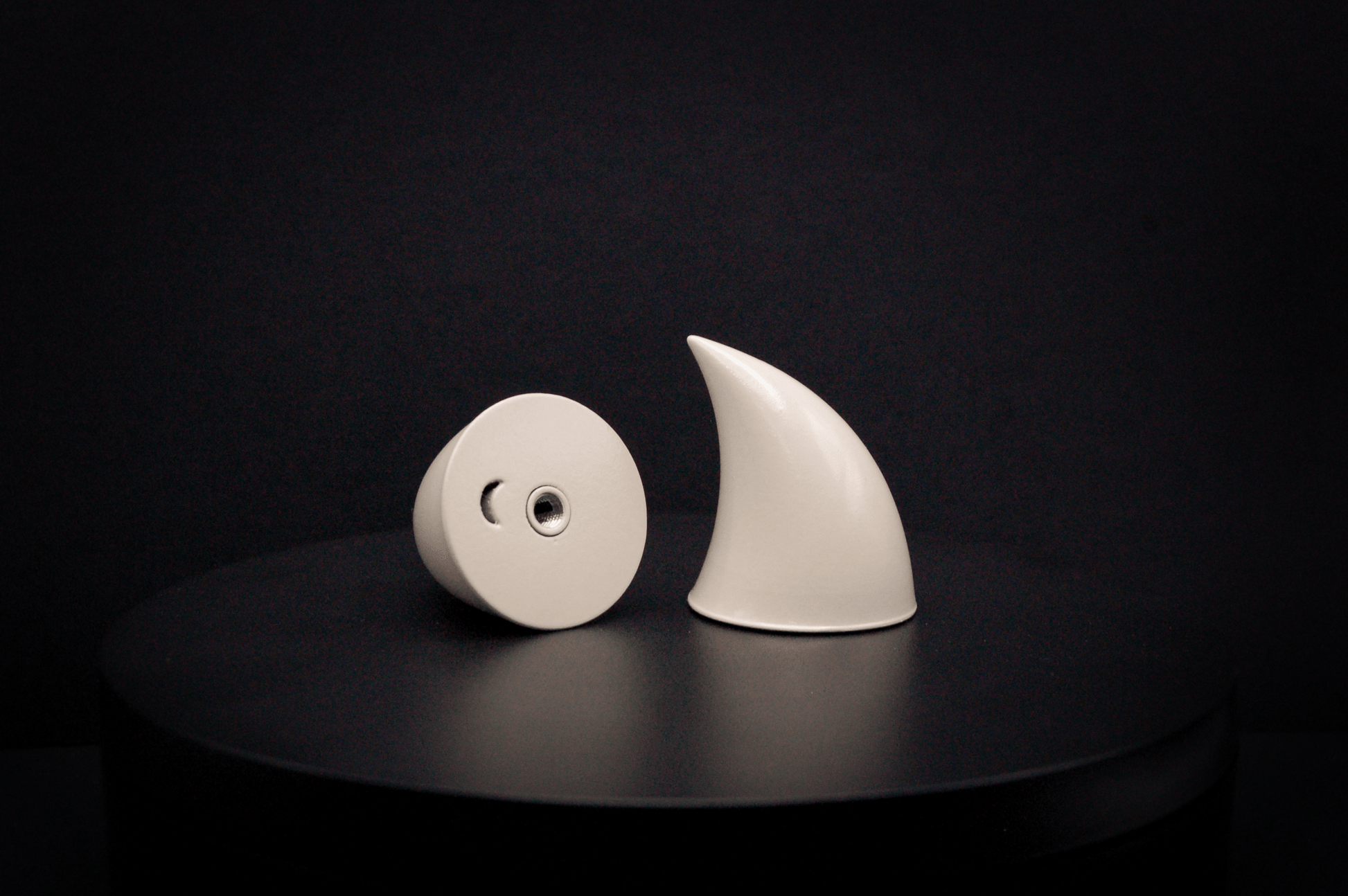 Bottom view of imp devil horns in bone white with a glossy finish, showing a threaded insert on the base.