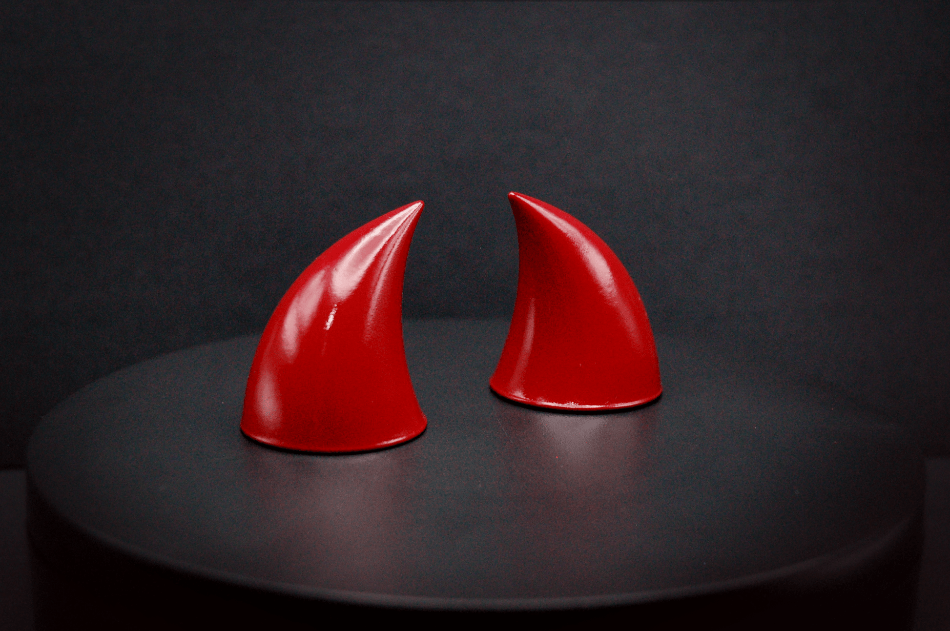 Side view of imp devil horns in bordeaux red with a glossy finish.