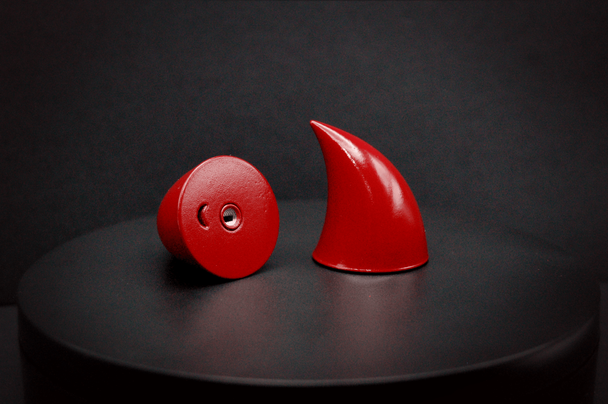 Bottom view of imp devil horns in bordeaux red with a glossy finish, showing a threaded insert on the base.