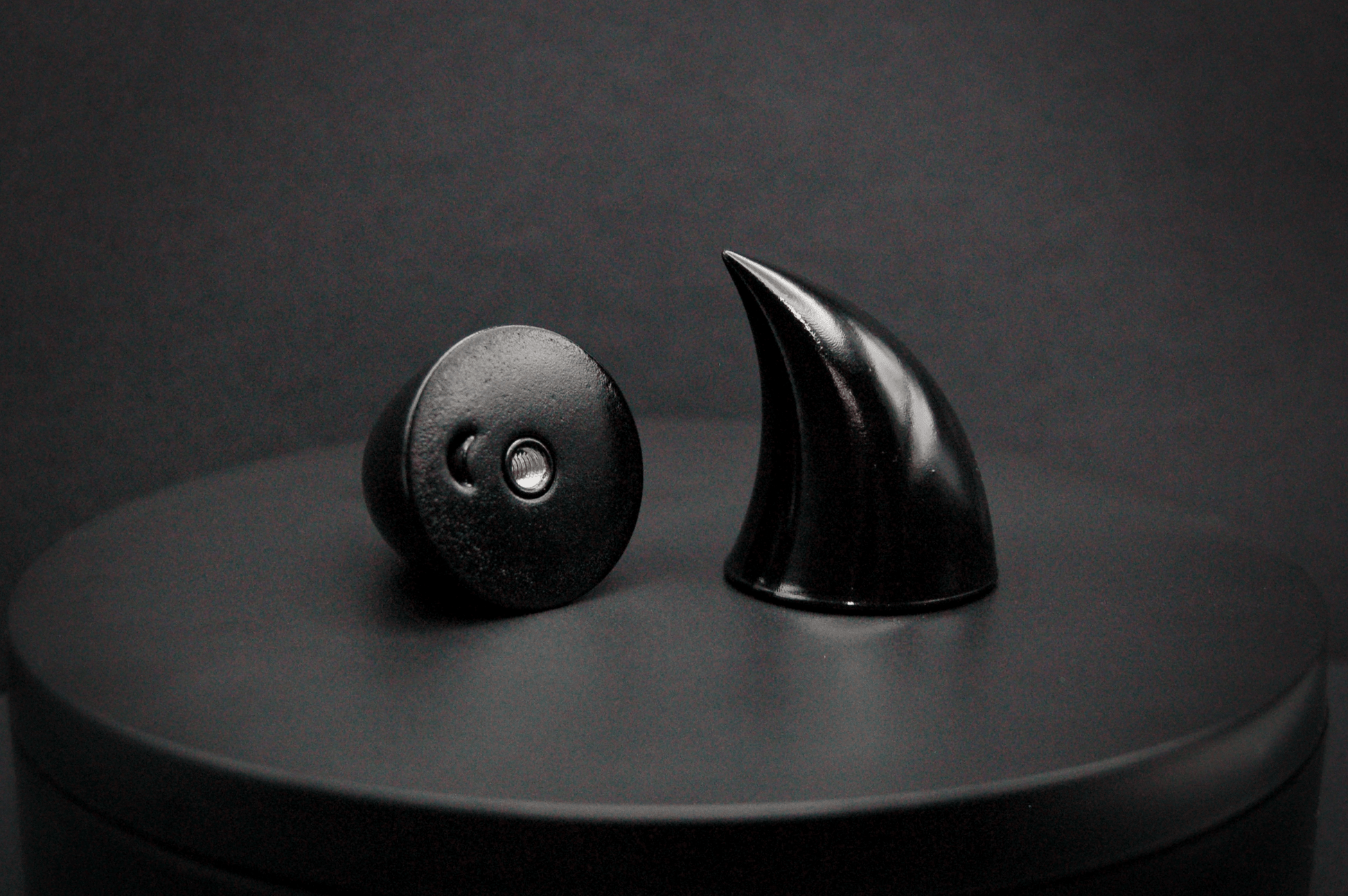 Bottom view of imp devil horns in black with a glossy finish, showing a threaded insert on the base.