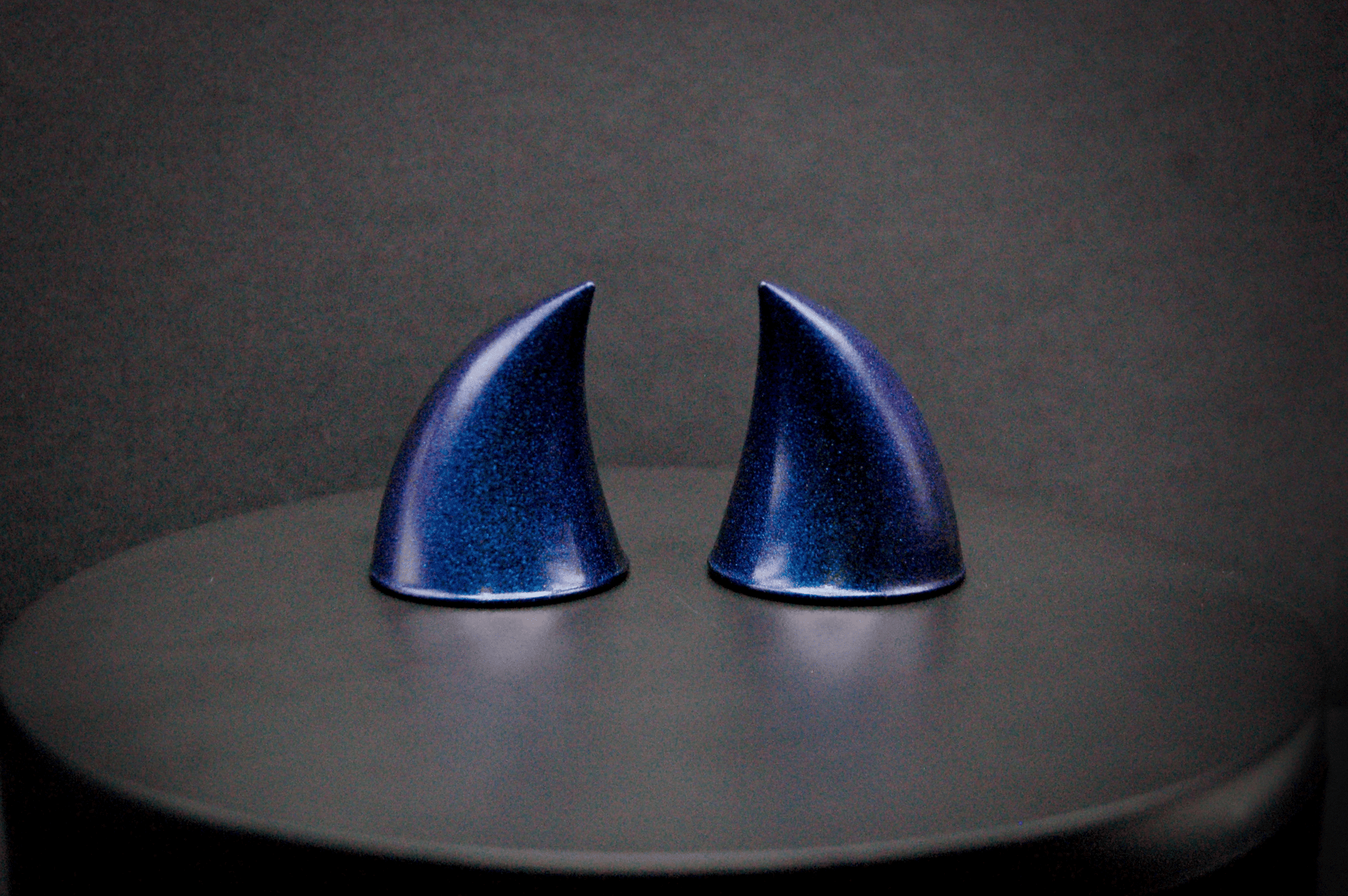Back view of imp devil horns in metallic violet-blue.