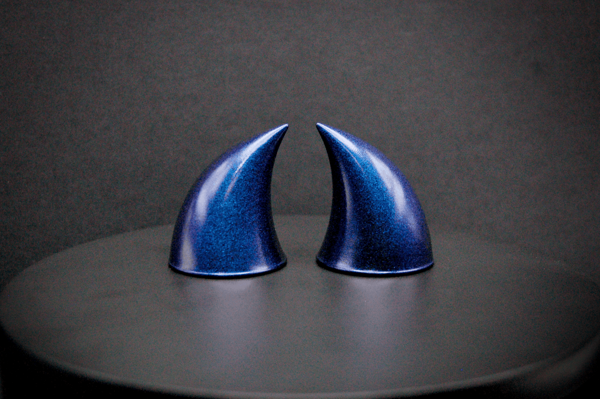 Side view of imp devil horns in metallic violet-blue.