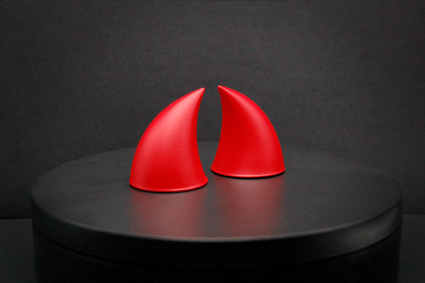 Side view of imp devil horns in scarlet red with a matte finish.