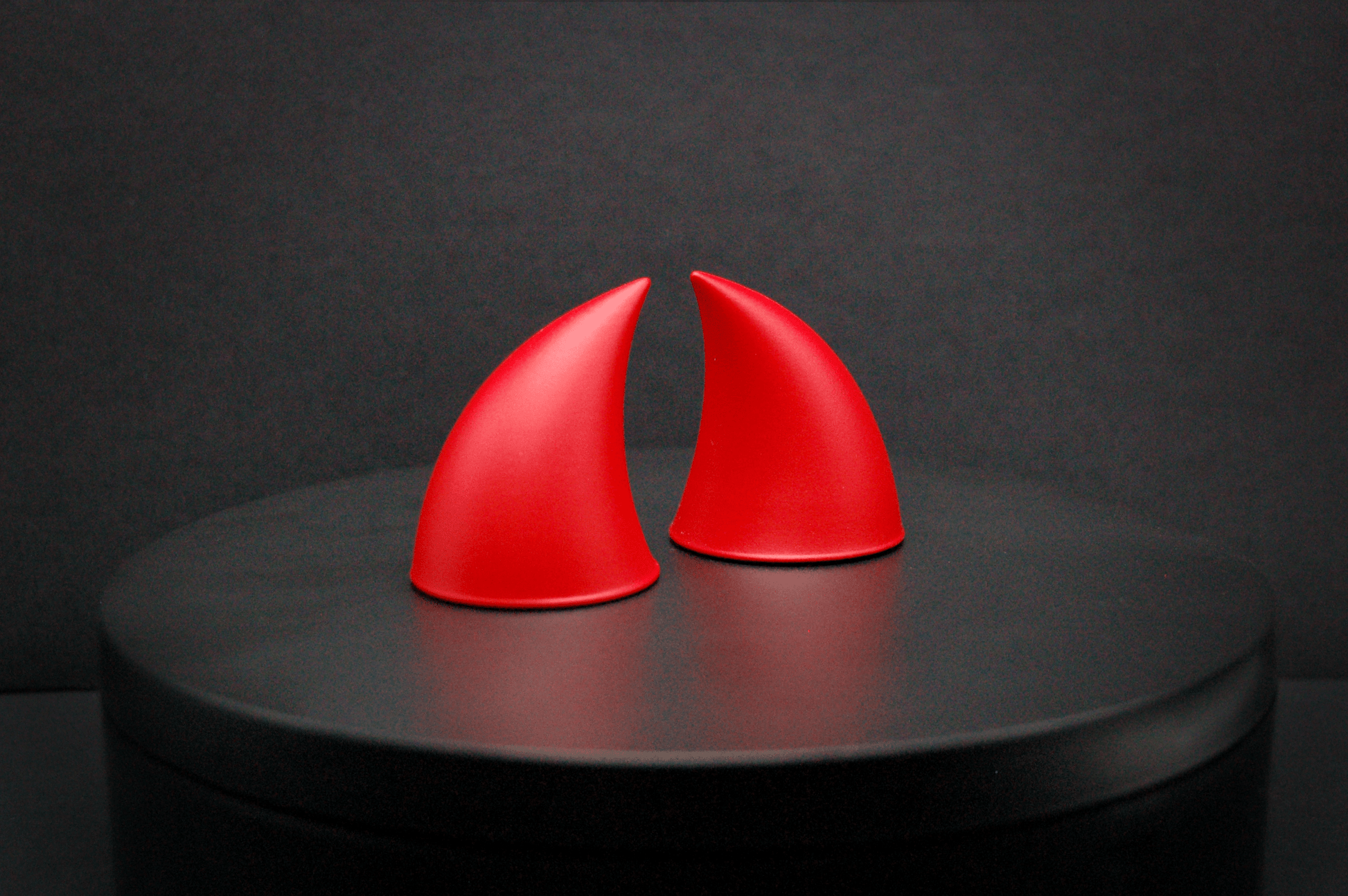 Side view of imp devil horns in scarlet red with a matte finish.