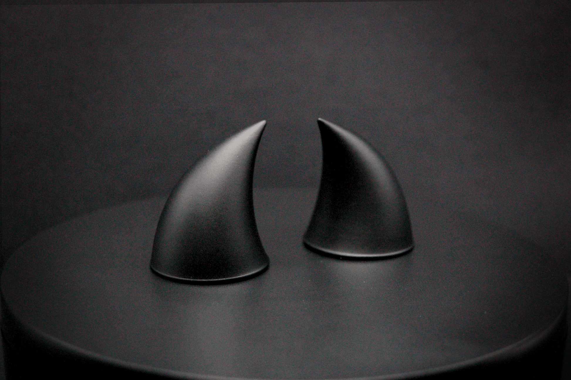 Side view of imp devil horns in black with a matte finish.