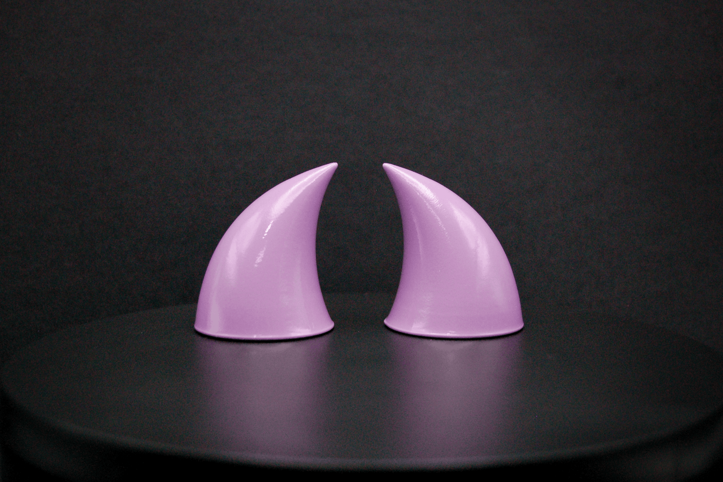 Side view of imp devil horns in lilac with a glossy finish.