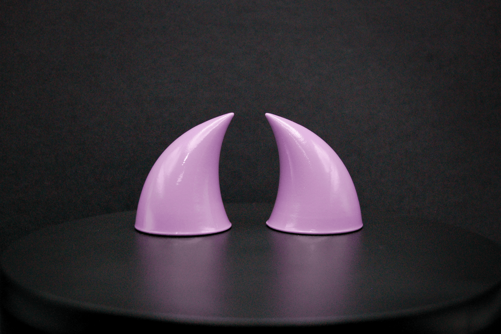 Side view of imp devil horns in lilac with a glossy finish.