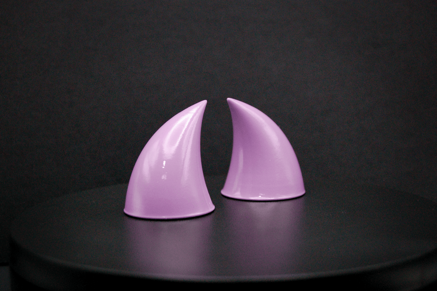 Side view of imp devil horns in lilac with a glossy finish.