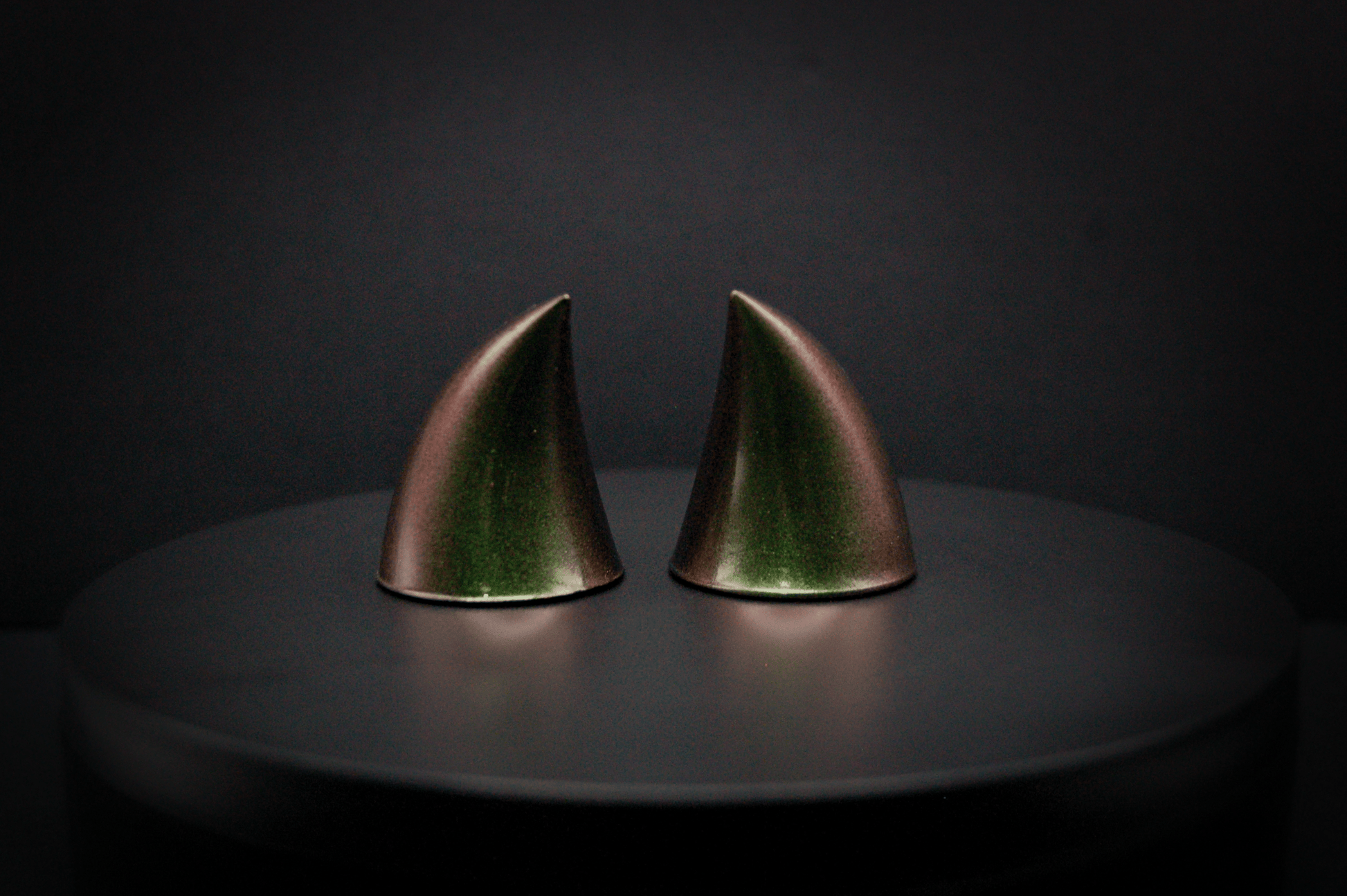 Back view of imp devil horns in metallic coppery green.