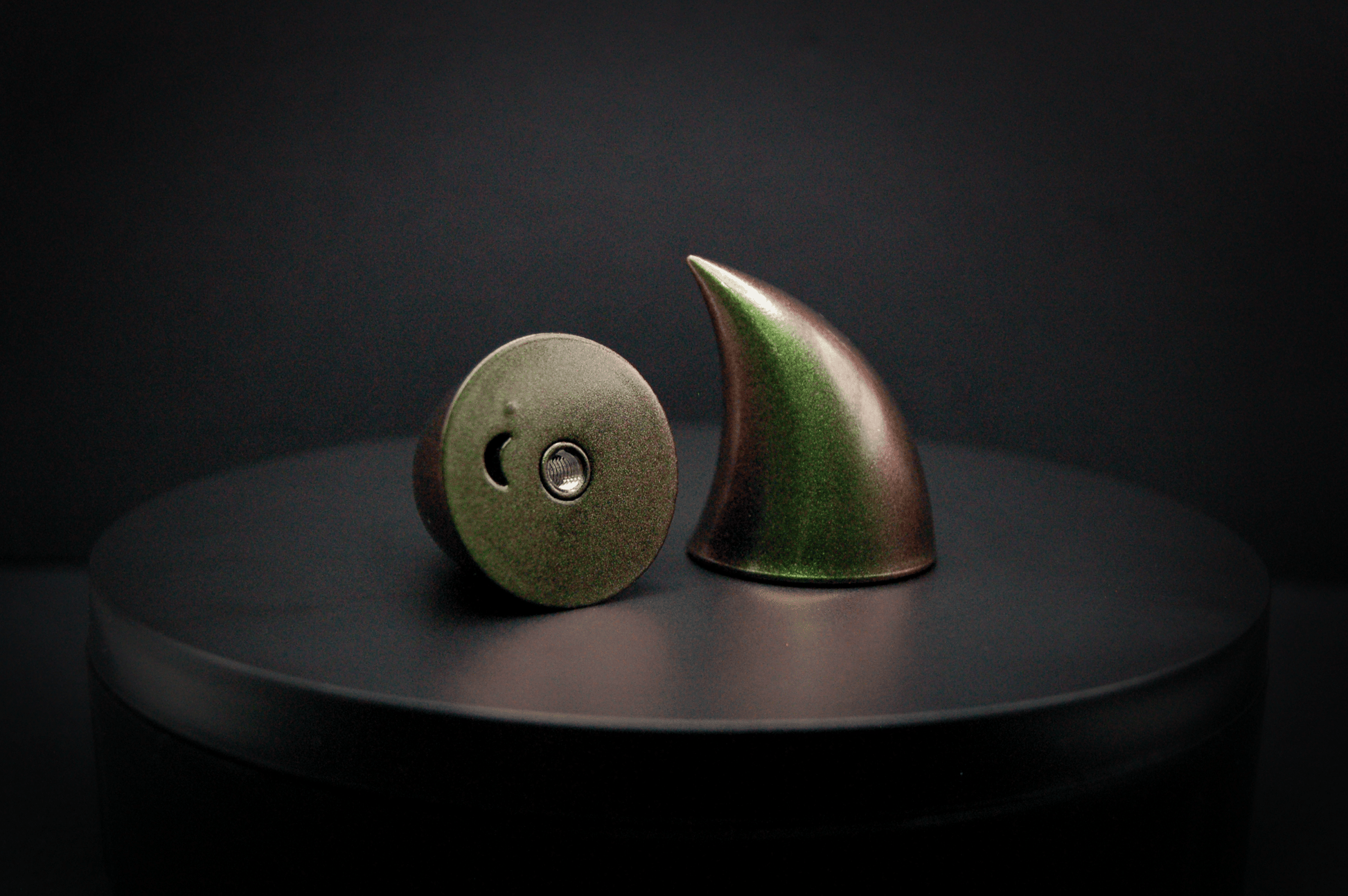 Bottom view of imp devil horns in metallic coppery green, showing a threaded insert on the base.