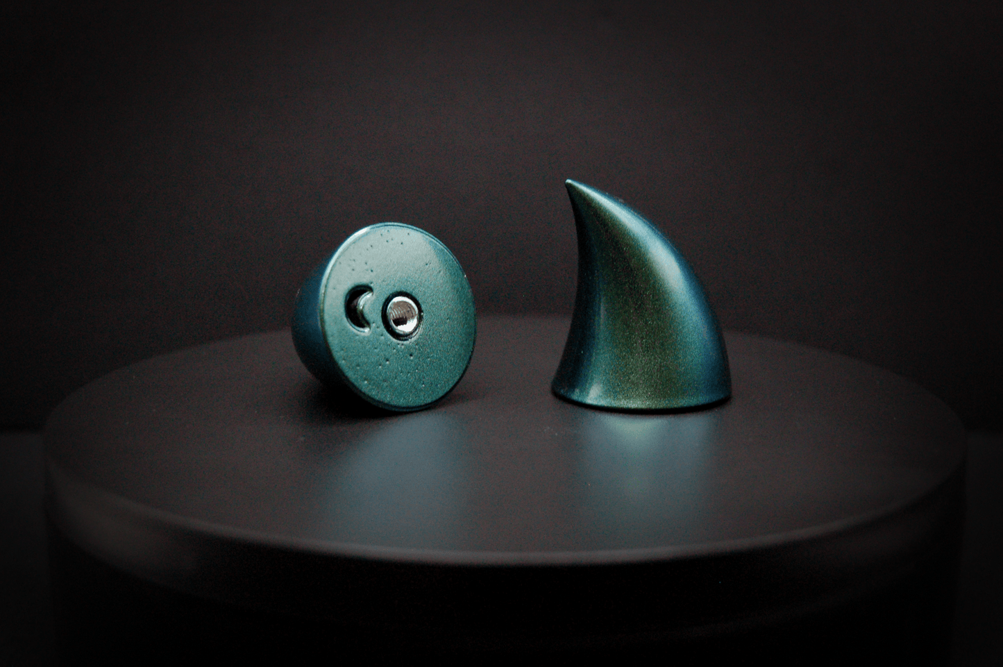Bottom view of imp devil horns in metallic blue-green, showing a threaded insert on the base.