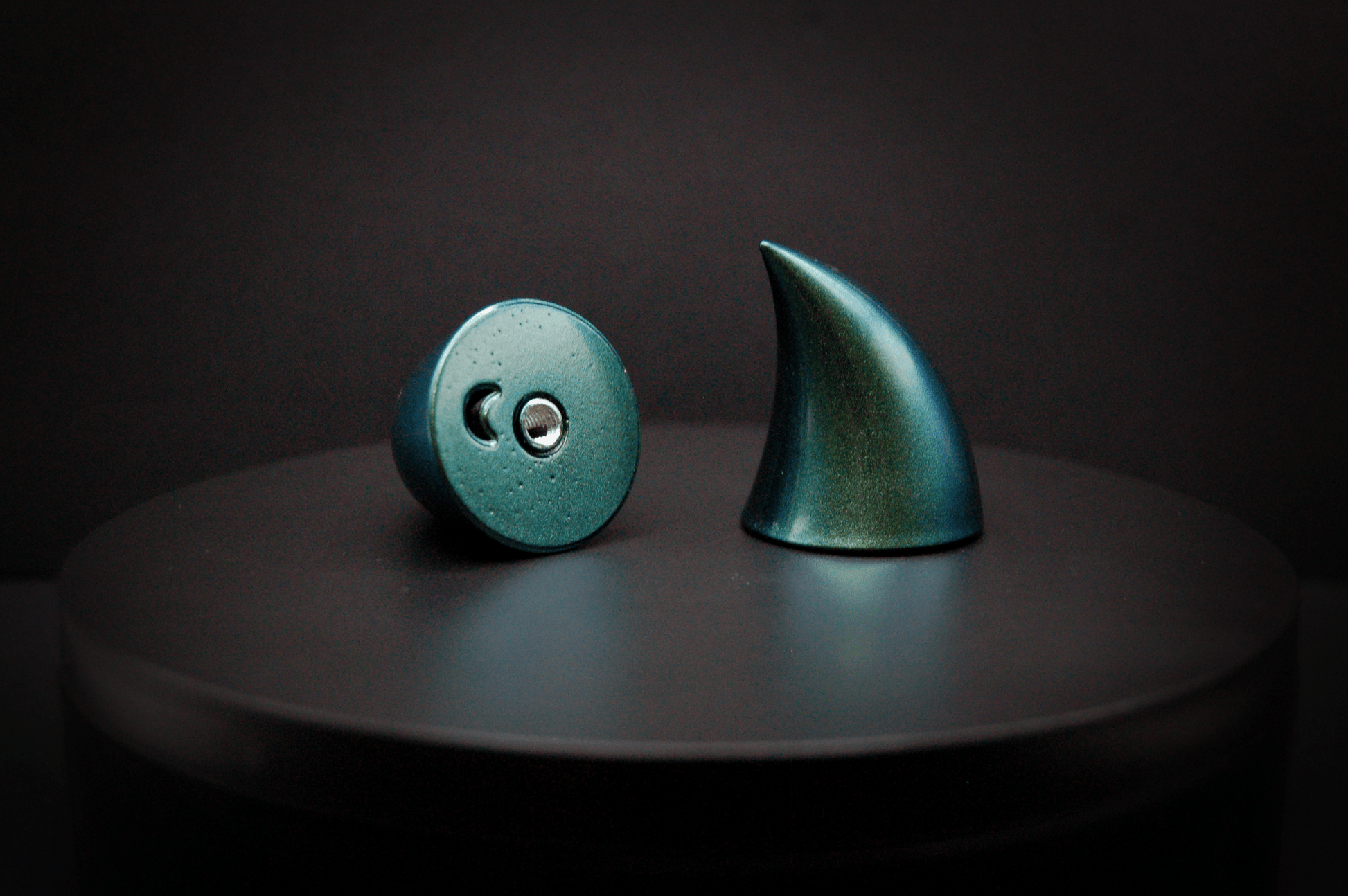 Bottom view of imp devil horns in metallic blue-green, showing a threaded insert on the base.