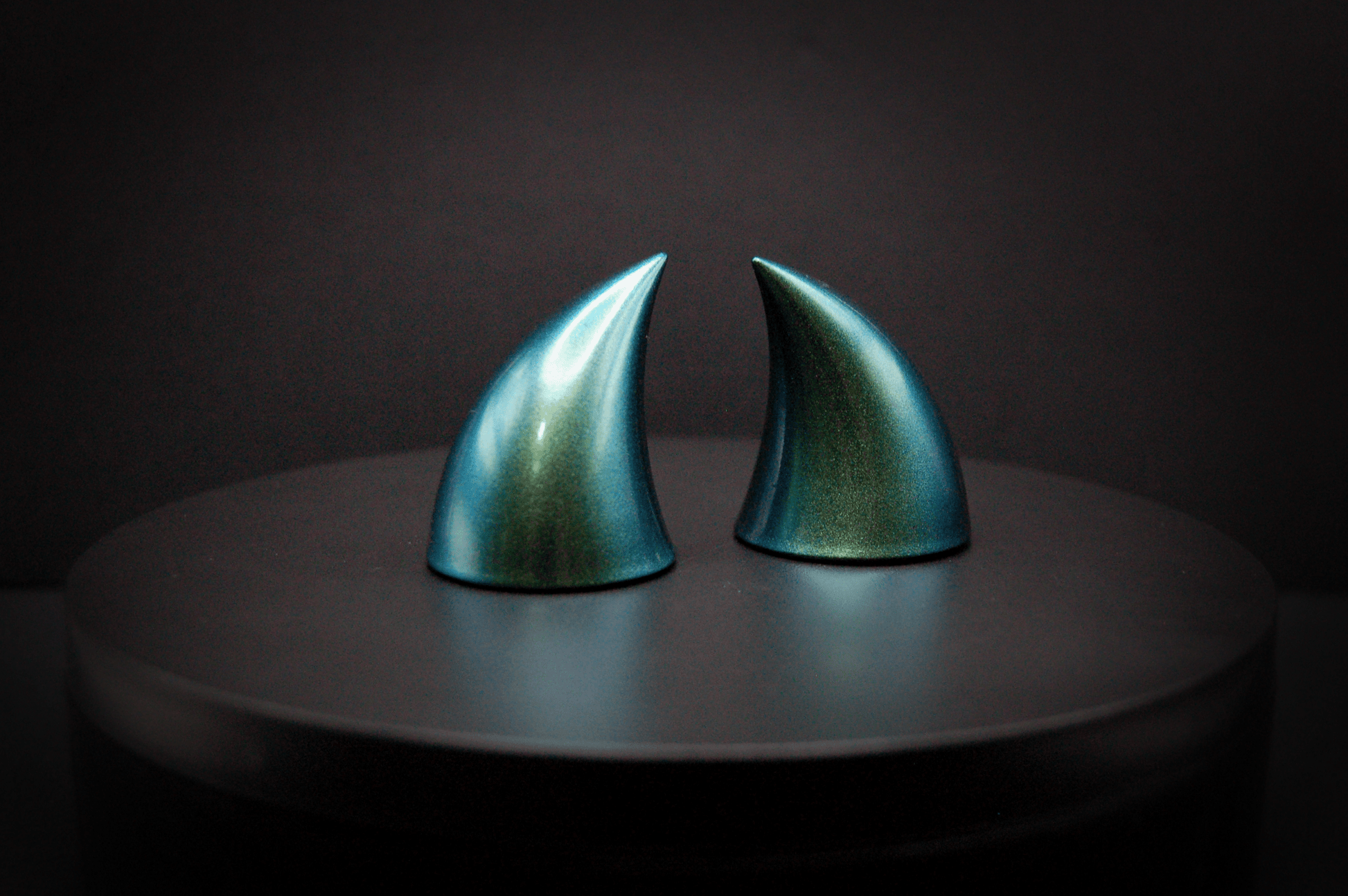 Side view of imp devil horns in metallic blue-green.