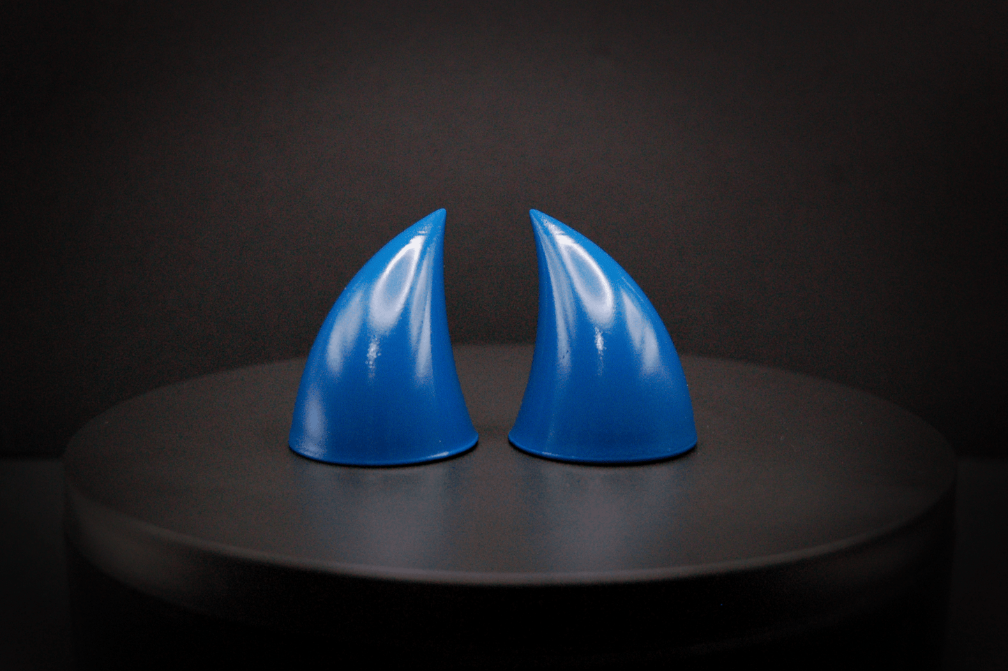 Front view of imp devil horns in storm blue, a deep blue with a glossy finish.