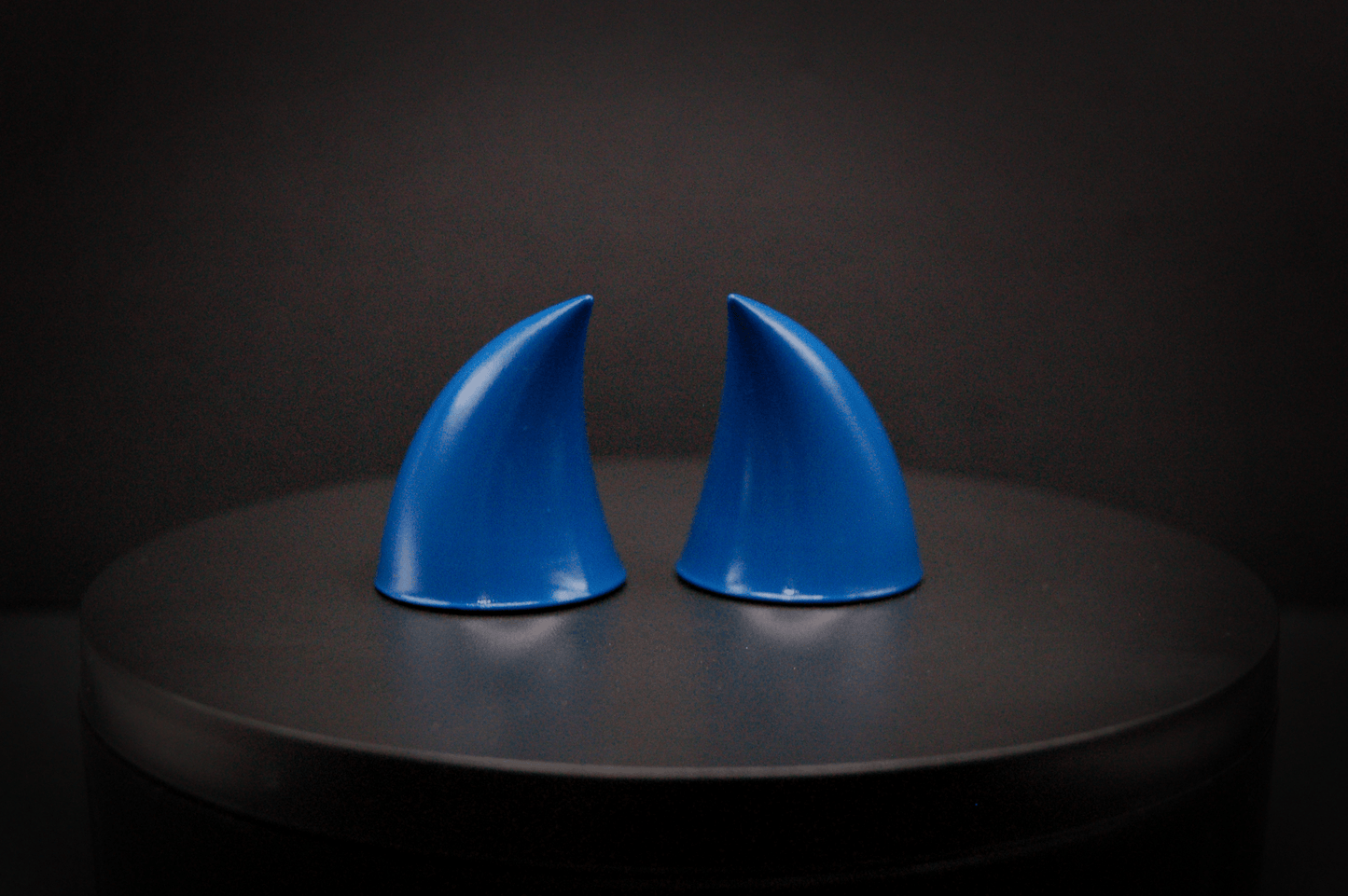 Back view of imp devil horns in storm blue, a deep blue with a glossy finish.